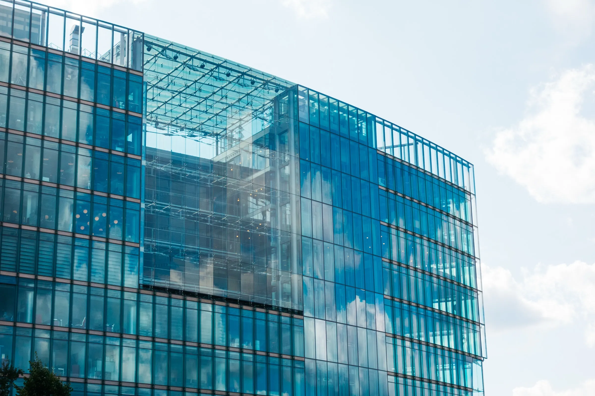 Glasbürogebäude mit geometrischer Fassade und blauem Himmel