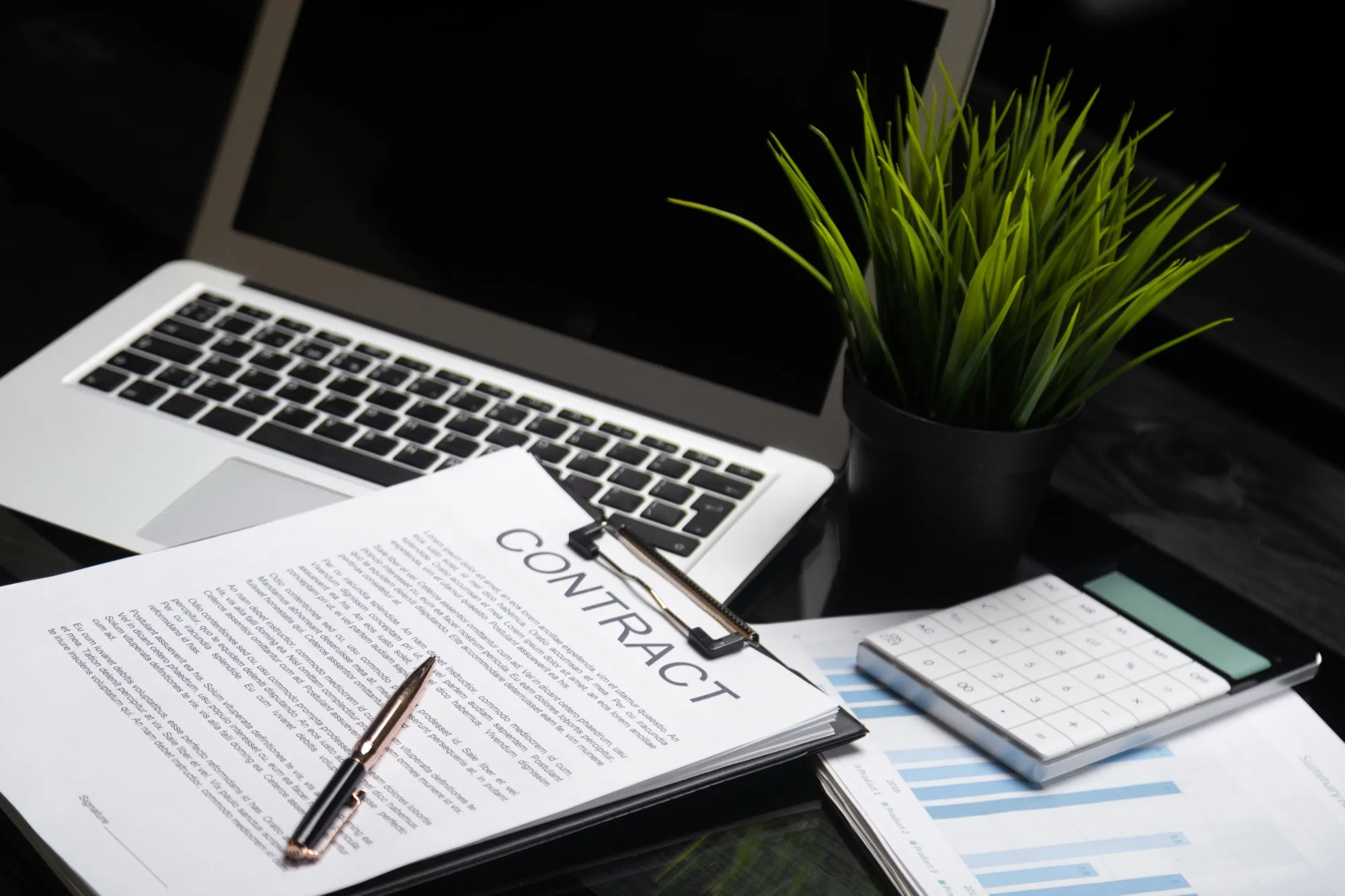 Arbeitsplatz mit Laptop und Vertragsunterlagen